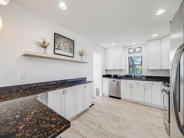 kitchen with dark stone counters, appliances with stainless steel finishes, open shelves, and white cabinetry