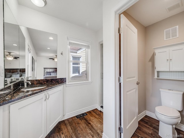 bathroom featuring a ceiling fan, visible vents, wood finished floors, baseboards, and ensuite bathroom