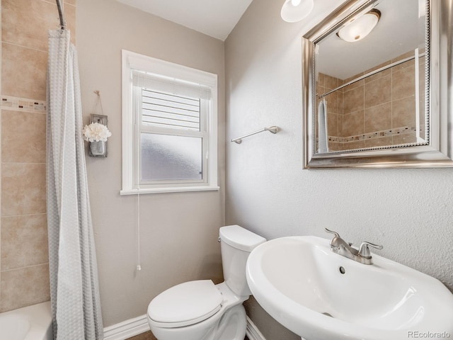 bathroom featuring a sink, toilet, and shower / tub combo