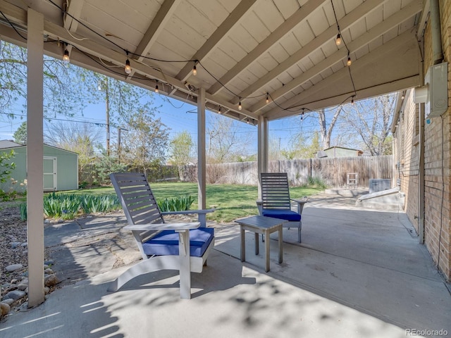view of patio / terrace featuring a storage shed, an outbuilding, and a fenced backyard