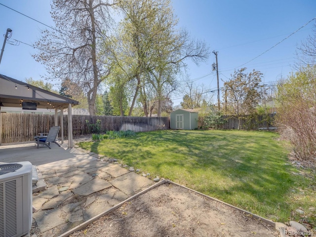 view of yard featuring a patio, central AC, a fenced backyard, and a storage unit