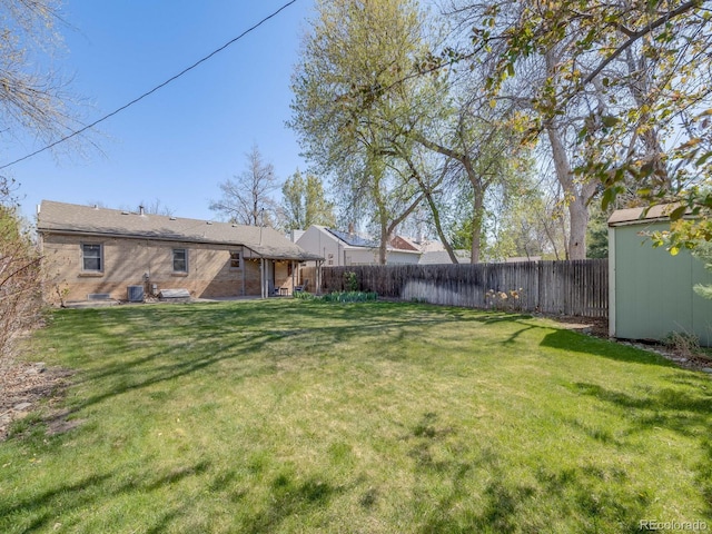 view of yard featuring an outdoor structure, cooling unit, a storage shed, and a fenced backyard