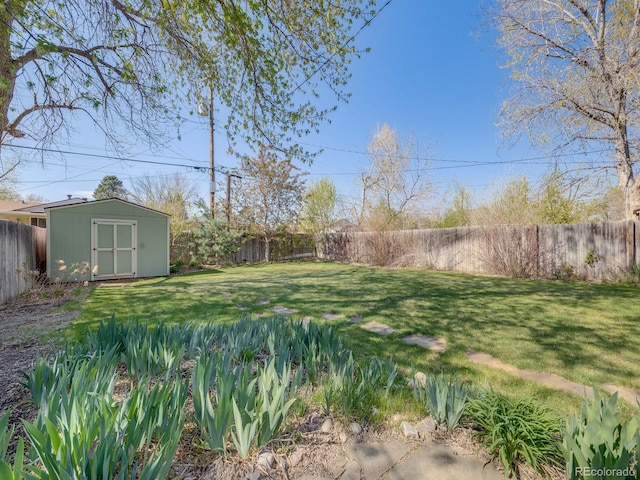 view of yard featuring an outdoor structure, a fenced backyard, and a storage unit