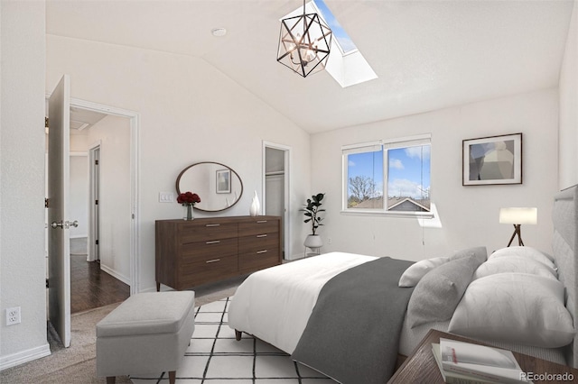 bedroom featuring lofted ceiling, a skylight, and baseboards