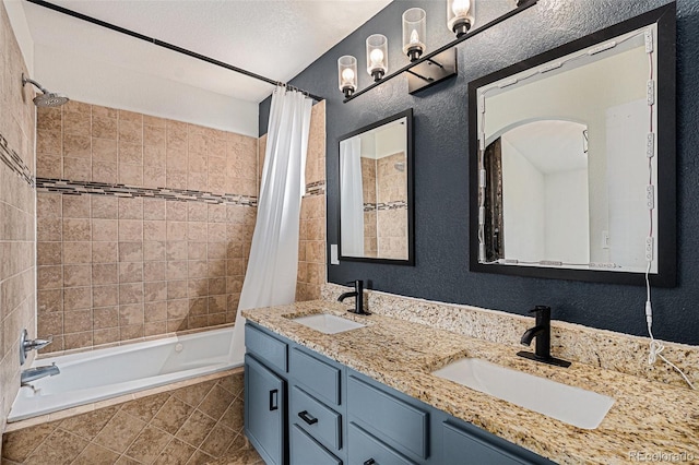 bathroom featuring tiled shower / bath combo, a textured wall, and double vanity