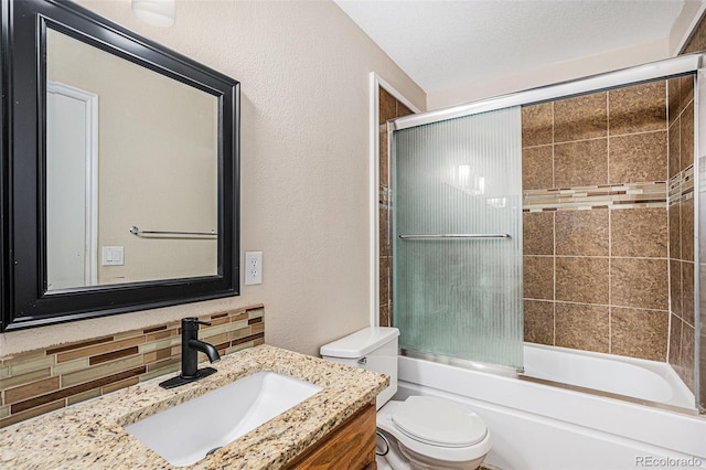 full bath with toilet, a textured wall, vanity, shower / bath combination with glass door, and backsplash