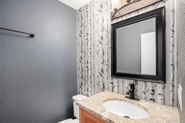 2791 S Bahama Ct, Aurora, CO 80013 - bathroom featuring vanity, toilet, and a textured wall