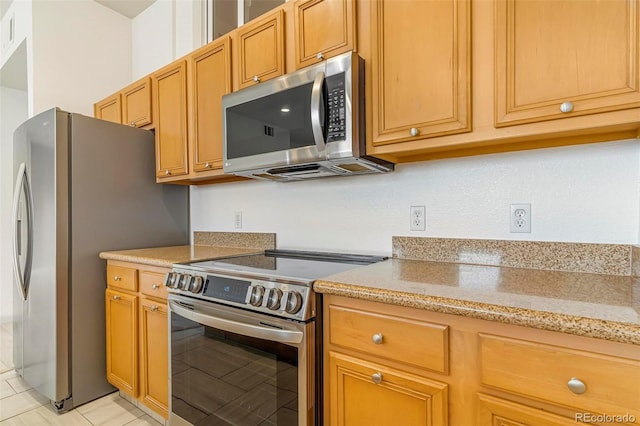 kitchen with appliances with stainless steel finishes and light stone countertops