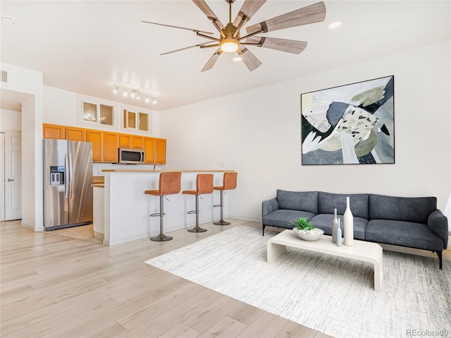 living room featuring ceiling fan and light wood-style floors