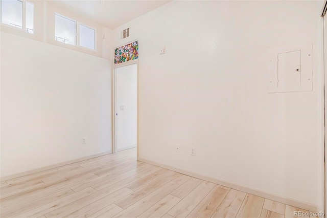 unfurnished room with baseboards, visible vents, and light wood-style floors