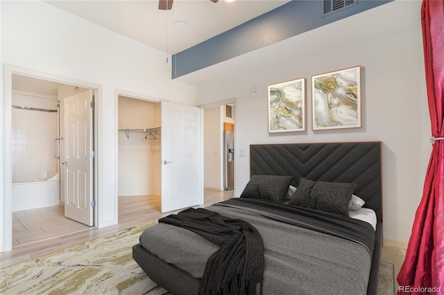 bedroom with connected bathroom, visible vents, a closet, stainless steel fridge with ice dispenser, and light wood finished floors