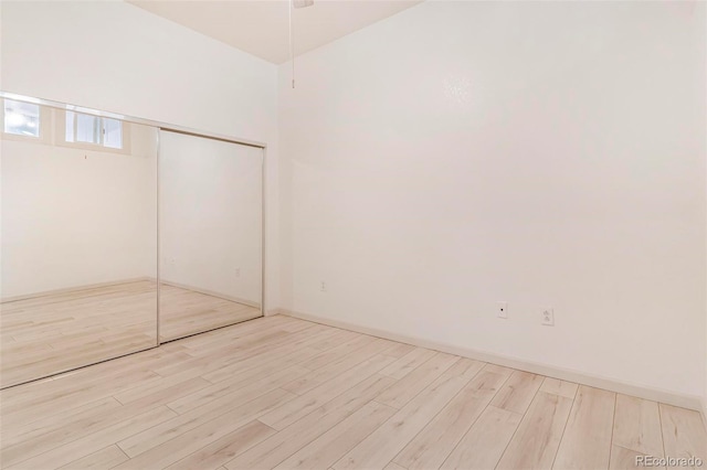 interior space with a closet, baseboards, and wood finished floors