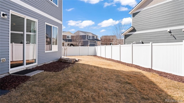 view of yard with a fenced backyard and a residential view