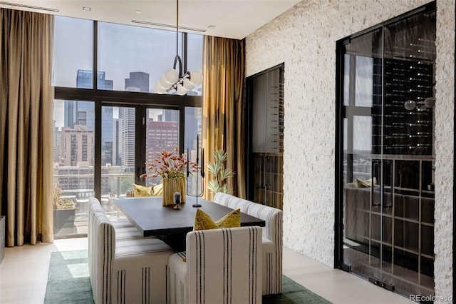 dining area with an inviting chandelier, floor to ceiling windows, and light wood-type flooring