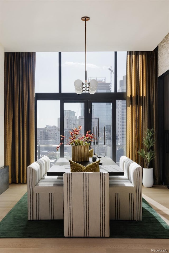 living room with a wall of windows, a chandelier, hardwood / wood-style floors, and a wealth of natural light