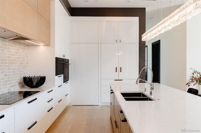 kitchen with white cabinets, sink, backsplash, and black appliances