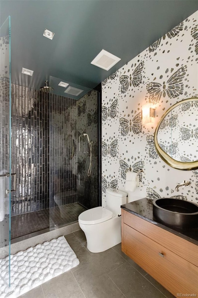 bathroom featuring tiled shower, tile patterned floors, toilet, and vanity