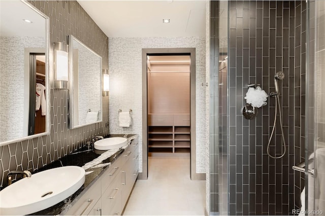 bathroom featuring vanity, tiled shower, tile walls, and decorative backsplash