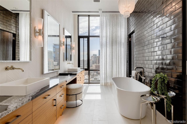 bathroom with tile patterned flooring, vanity, and a bath