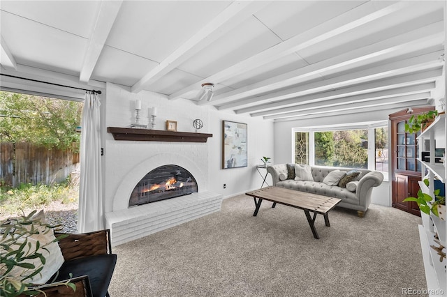 carpeted living room featuring a brick fireplace and beamed ceiling