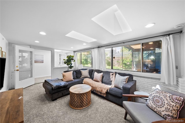 living room featuring a skylight, recessed lighting, and carpet floors