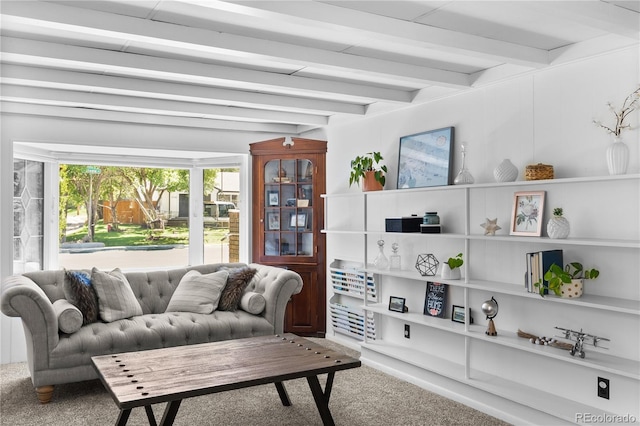 carpeted living area featuring beamed ceiling