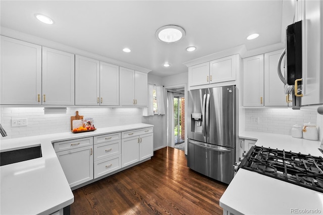 kitchen featuring appliances with stainless steel finishes, a sink, light countertops, white cabinets, and recessed lighting