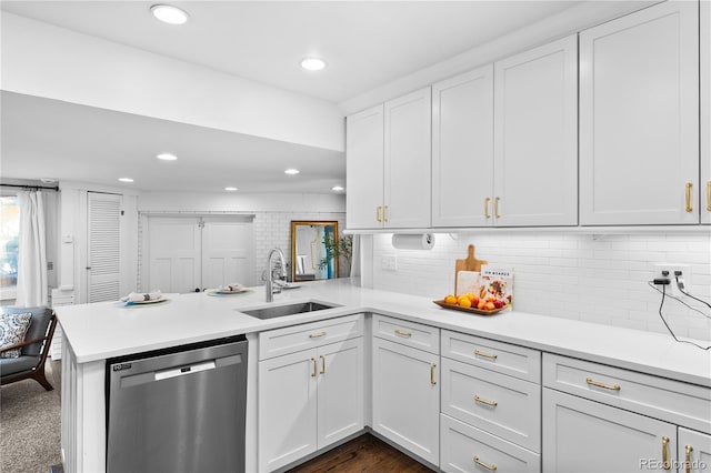 kitchen with stainless steel dishwasher, a sink, a peninsula, light countertops, and recessed lighting