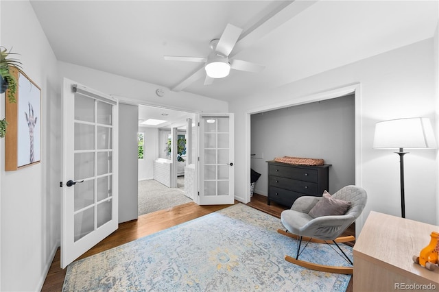 living area with french doors, wood finished floors, a ceiling fan, and baseboards