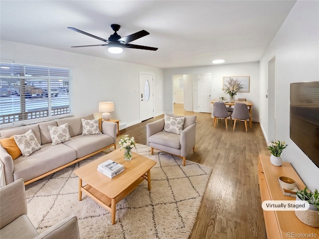 living room with ceiling fan and wood-type flooring