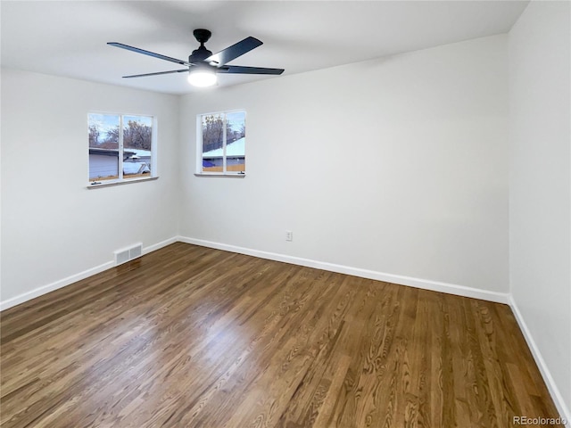 empty room with dark hardwood / wood-style floors and ceiling fan