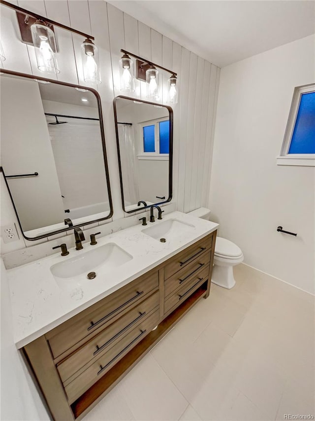 bathroom featuring tile patterned flooring, vanity, toilet, and wooden walls