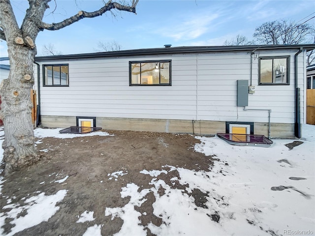 view of snow covered rear of property