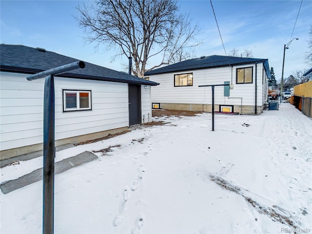 view of snow covered back of property