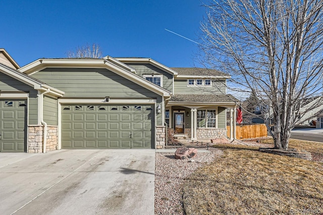 view of front of property featuring a garage, covered porch, stone siding, and driveway