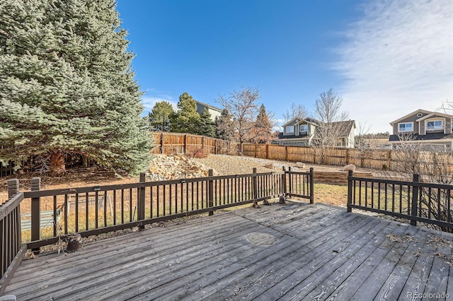 wooden terrace with a fenced backyard