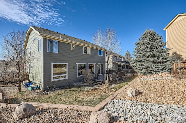 rear view of property with fence and a wooden deck