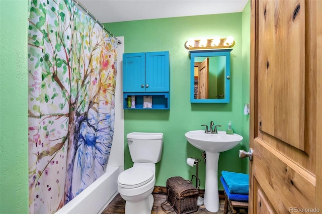 full bathroom featuring shower / bath combo with shower curtain, hardwood / wood-style floors, toilet, and sink