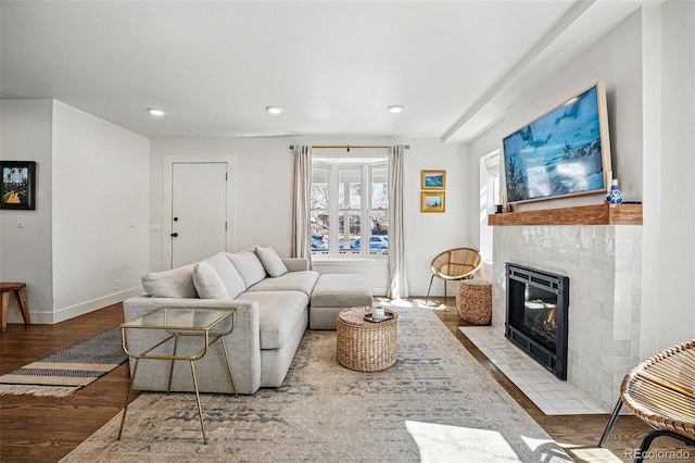 living room featuring recessed lighting, a fireplace, baseboards, and wood finished floors