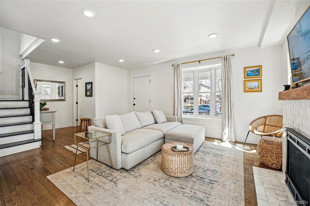 living room featuring recessed lighting, a fireplace, stairs, and wood finished floors