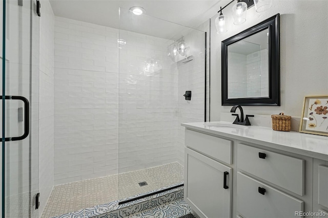 full bathroom featuring tile patterned floors, vanity, and a tile shower