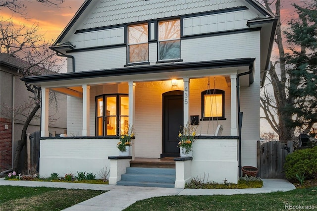 view of front of house with covered porch and fence