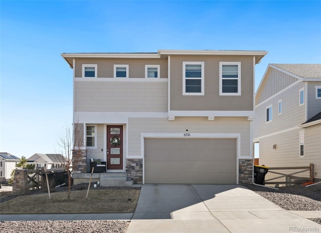 view of front of home with driveway, stone siding, and an attached garage