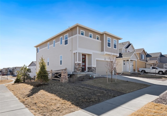 view of front of house featuring a garage, stone siding, concrete driveway, and a residential view