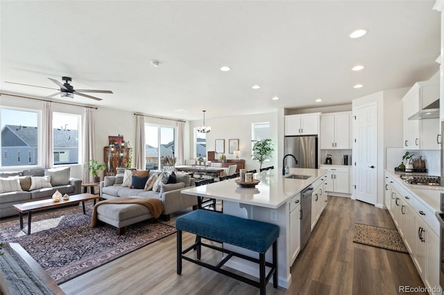 kitchen featuring appliances with stainless steel finishes, open floor plan, light countertops, and a sink