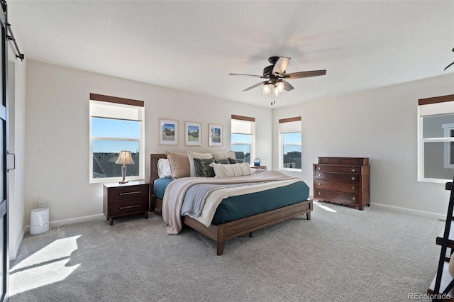 carpeted bedroom with ceiling fan and baseboards