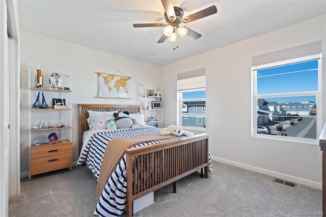 bedroom featuring ceiling fan, carpet flooring, visible vents, and baseboards