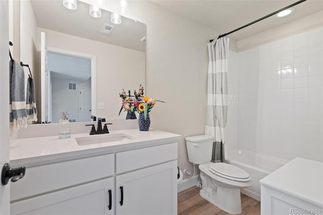 bathroom featuring toilet, shower / tub combo, wood finished floors, visible vents, and vanity