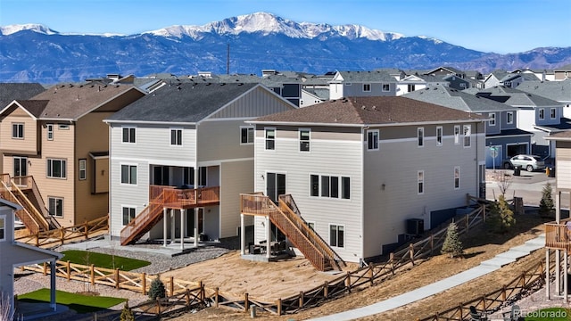 back of house featuring a fenced backyard, a residential view, stairway, a deck with mountain view, and cooling unit