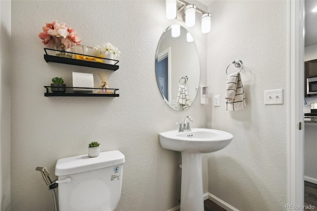 19221 E 65th Ave, Denver, CO 80249 - half bathroom with toilet and wood finished floors